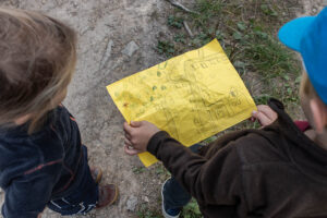 Dvě malé děti se dívají do ručně nakreslené mapy